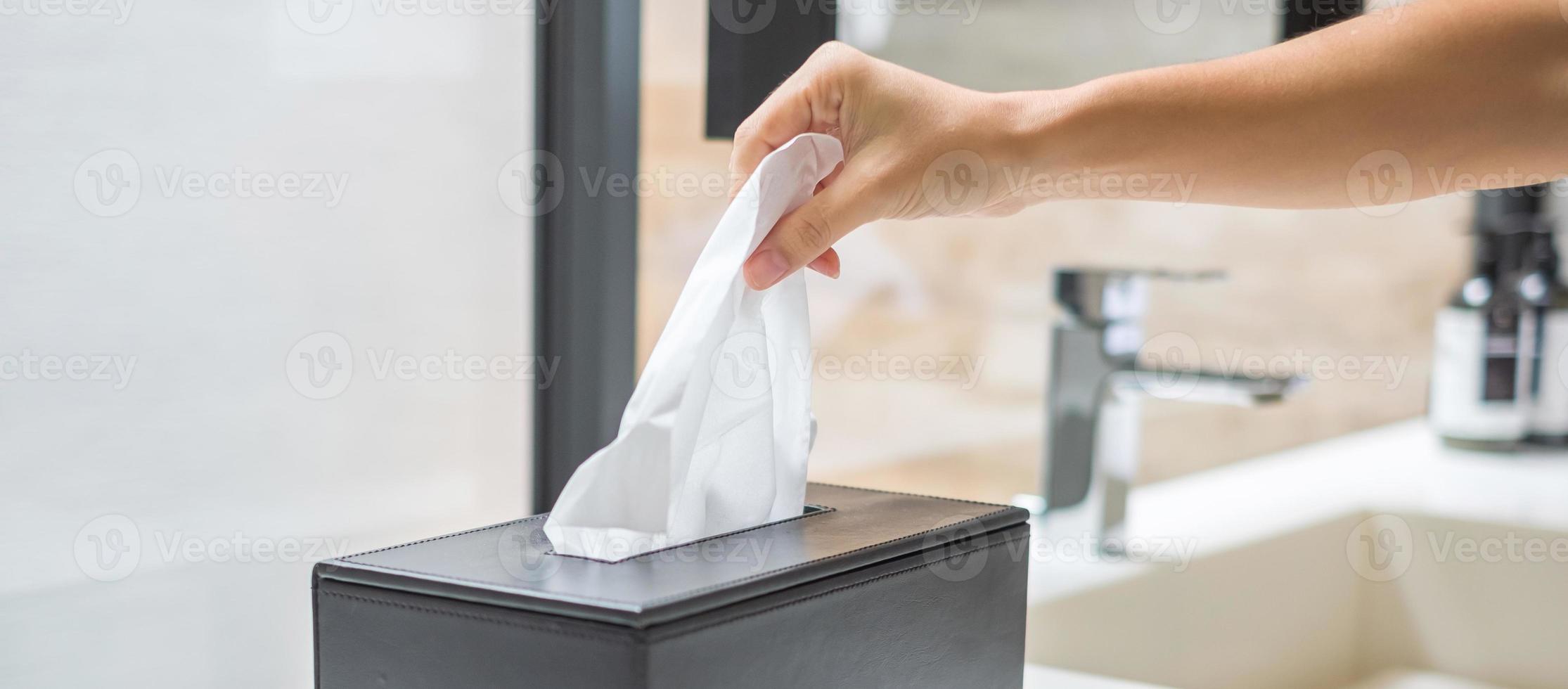 hand, die toilettenpapier im badezimmer zieht. konzept für reinigung, lebensstil und persönliche hygiene foto