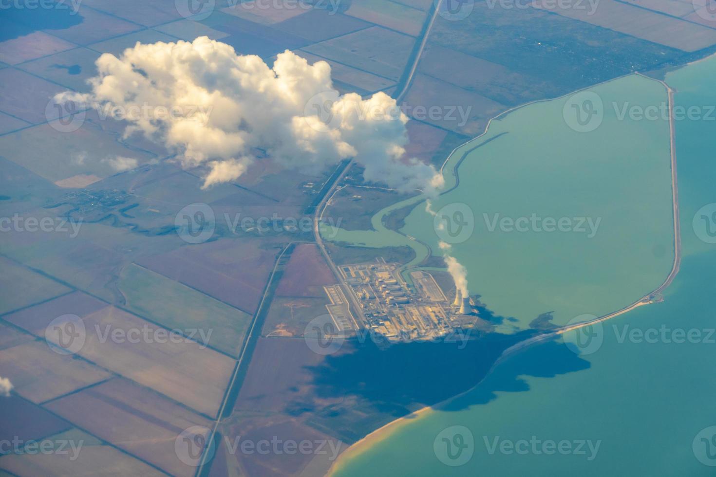 Luftbild von Ackerland. Blick aus dem Flugzeug auf den Boden. Quadrate von Feldern unter den Wolken foto