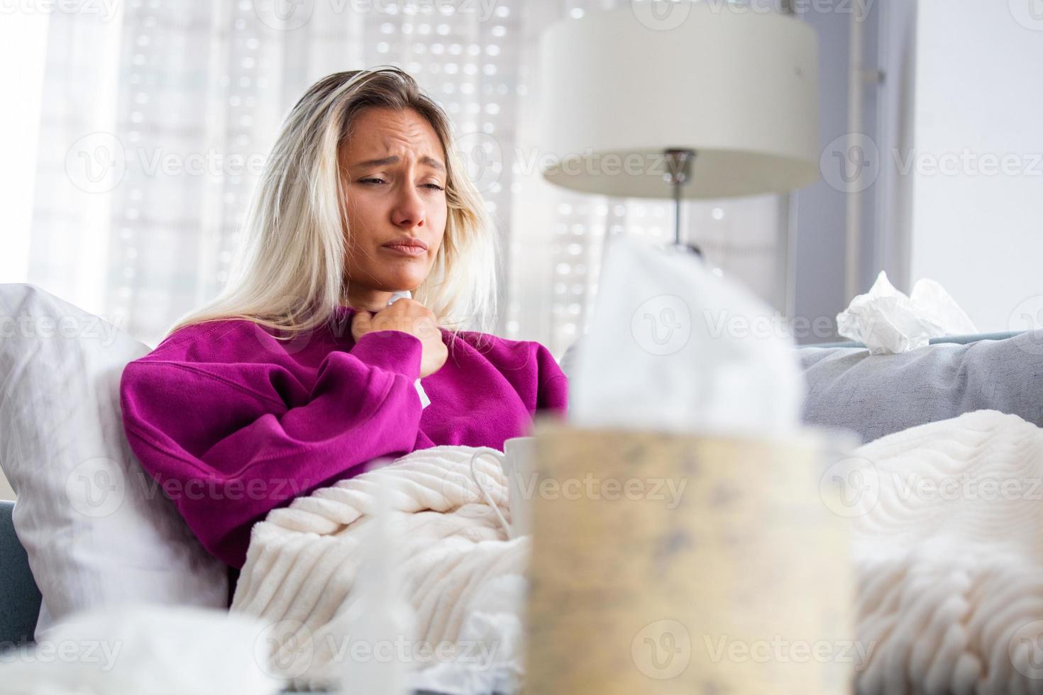 Erkältung und Grippe. porträt einer kranken frau, die erkältet ist, sich krank fühlt und in einem papiertuch niest. Nahaufnahme eines schönen ungesunden Mädchens, das mit einer Decke bedeckt ist, die die Nase abwischt. Gesundheitskonzept. hohe Auflösung foto