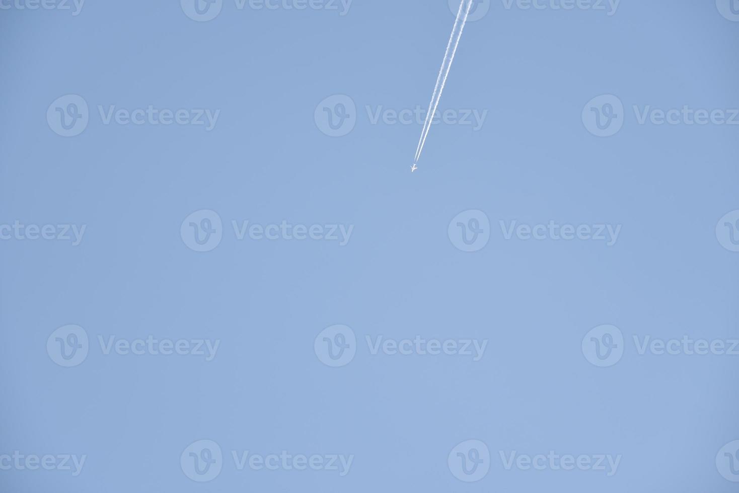 der Kondensstreifen eines Flugzeugs am blauen Himmel. der Flug eines Passagierflugzeugs. foto