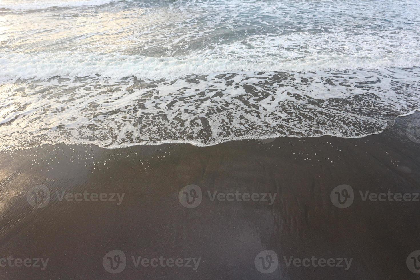 weiche welle des blauen ozeans am sandstrand. Hintergrund. foto