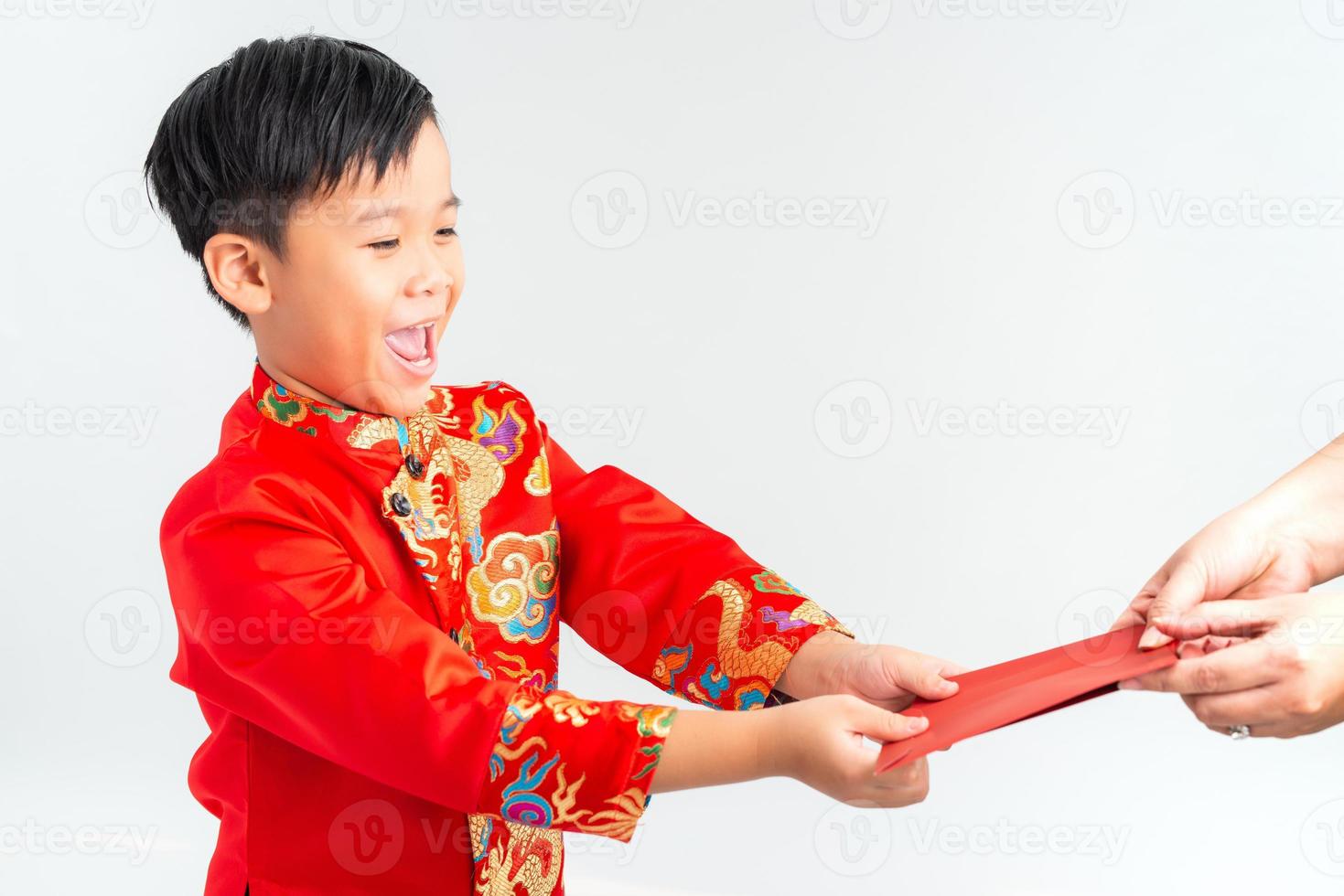asiatischer vietnamesischer junge, der rotes papierpaket oder geld von einem anderen auf dem neujahrsfest des mondes erhält, mit traditionellem ao dai isoliert auf weißem hintergrund. foto