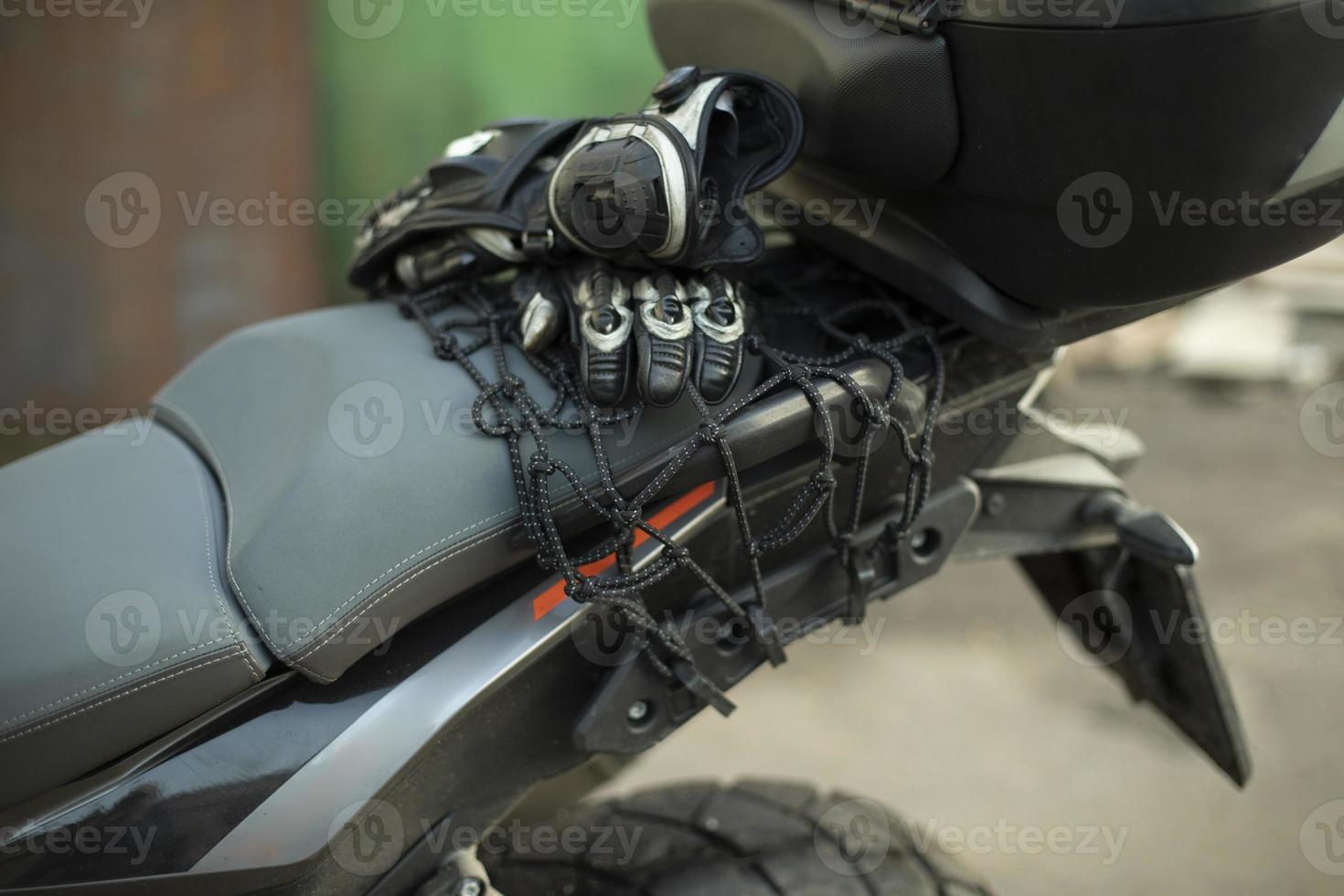 motorradfahrerhandschuhe sind am kofferraum. Motorrad ist im Detail. foto