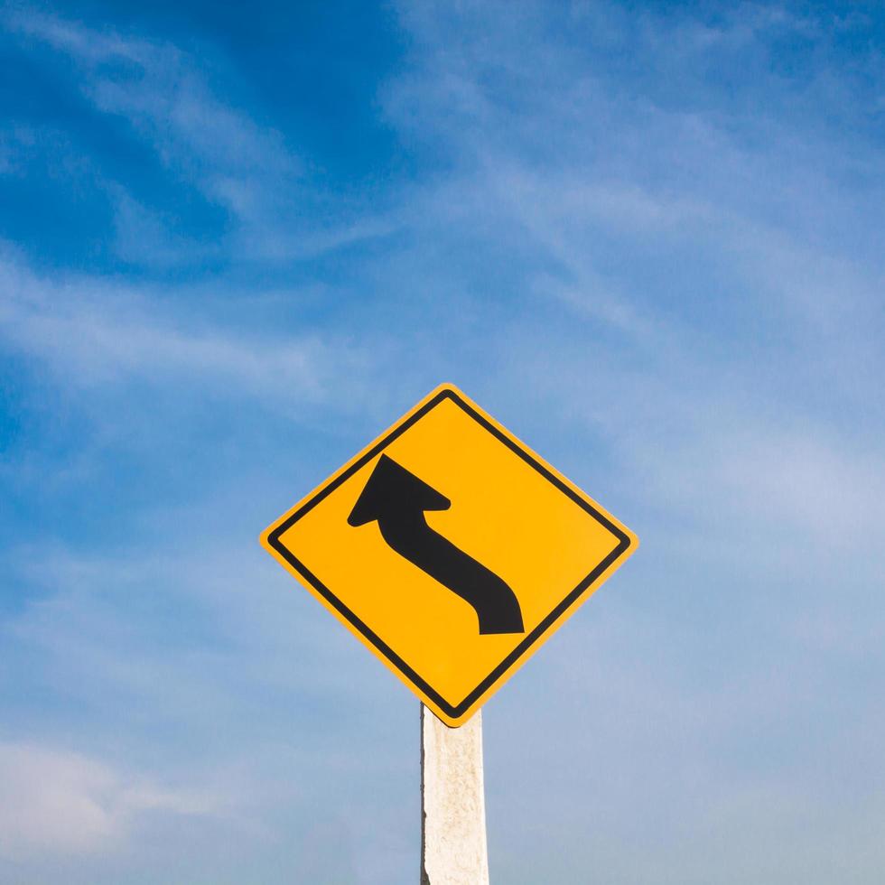 kurvenreiches Straßenschild mit blauem Himmel. foto