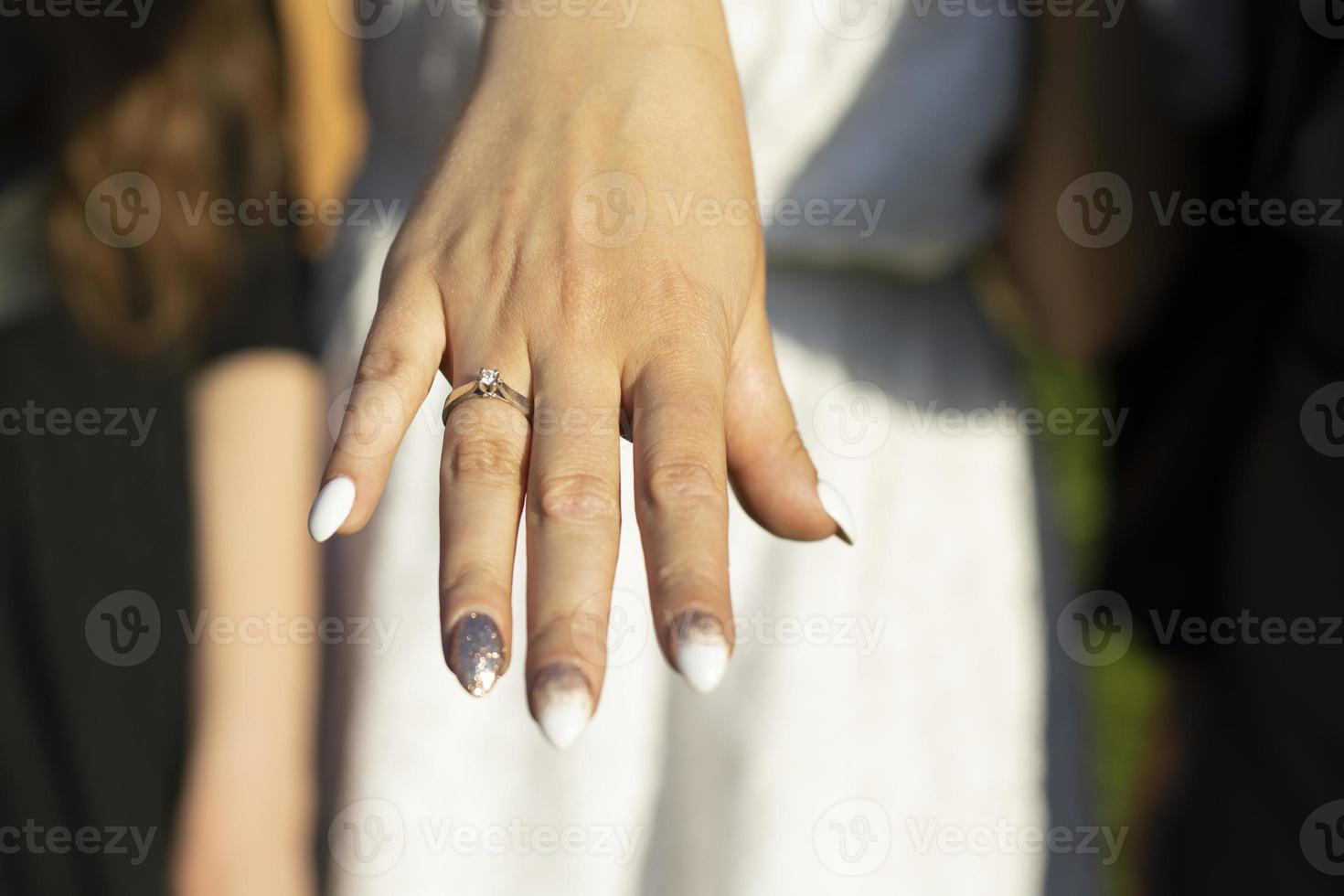 Ehering am Finger des Mädchens. Mädchenhand mit Ring. Details der Zeremonie. Hochzeitsfeier. foto