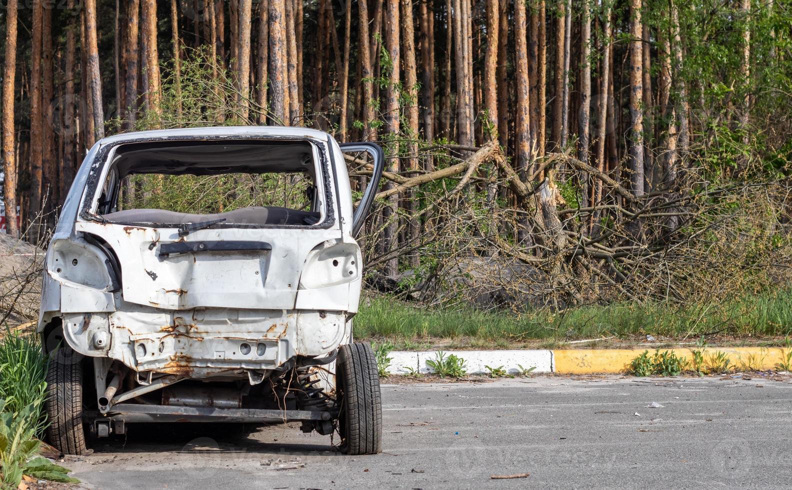 kaputter Kleinwagen nach einem Verkehrsunfall auf dem Parkplatz einer Reparaturwerkstatt. Karosserieschadenwerkstatt im Freien. Verkauf von Versicherungsautos auf einer Auktion. Schäden an der Karosserie nach dem Unfall. foto