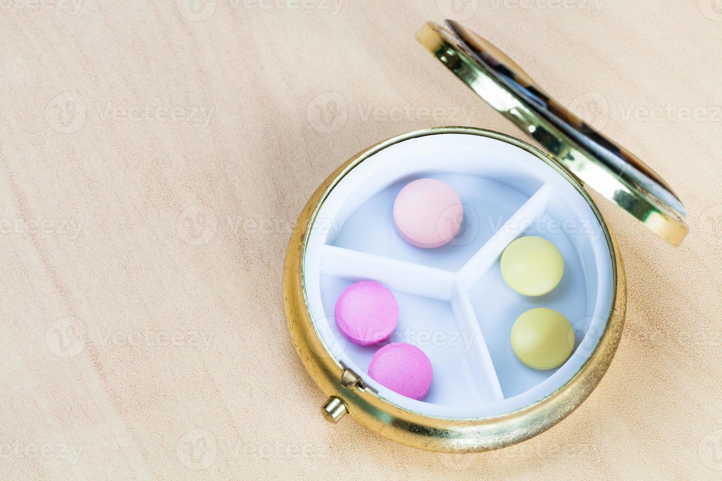Draufsicht auf die Pillendose mit rosa und gelben Pillen foto