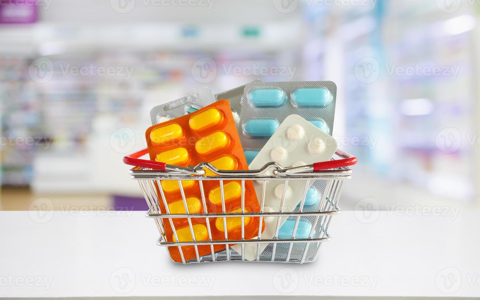 Medizinpillenpaket im Einkaufskorb mit Apotheken-Drogerieregalen verwischen den Hintergrund foto