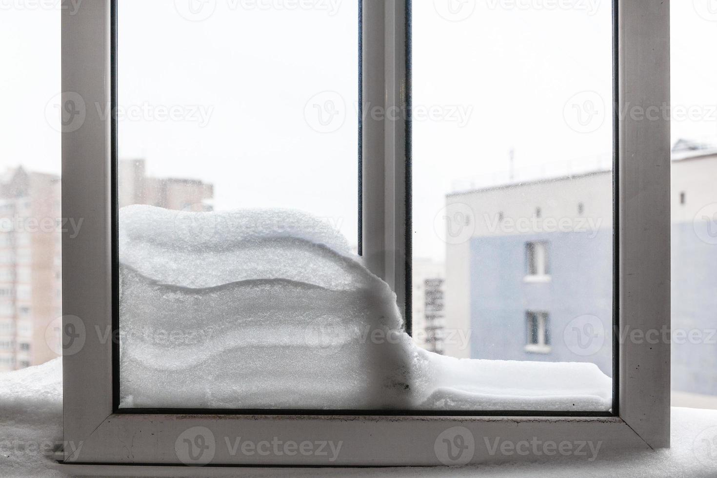 Schneewehe zwischen den Rahmen auf dem Balkon im Winter foto