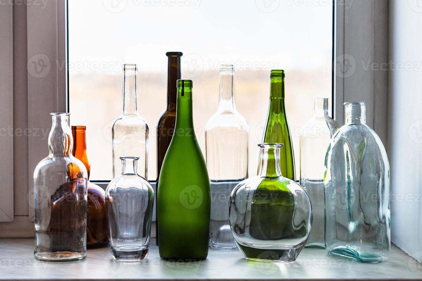 verschiedene Flaschen auf Fensterbank und Parkblick foto