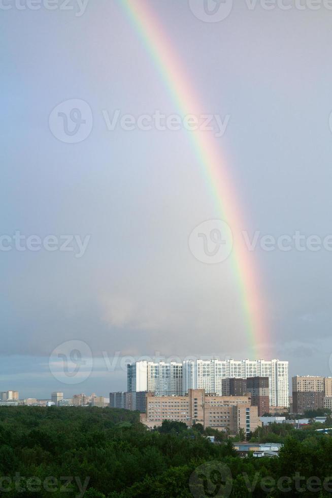 Regenbogen im blauen bewölkten Himmel über Hochhäusern foto