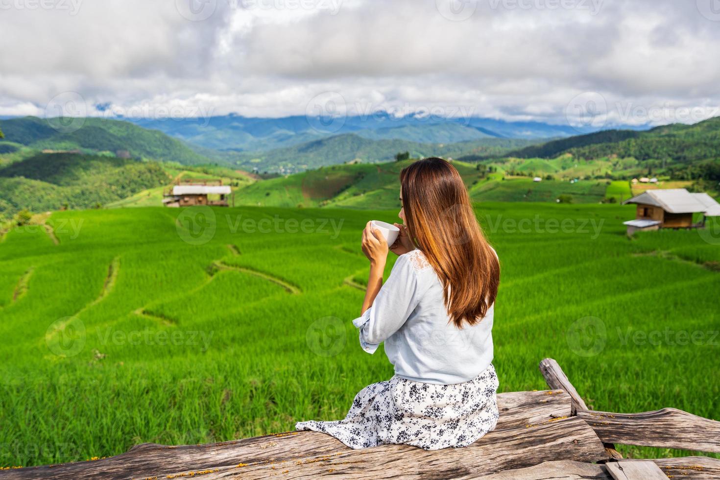 junge reisende im urlaub, der kaffee am schönen grünen reisterrassenfeld in pa pong pieng, chiangmai thailand trinkt foto