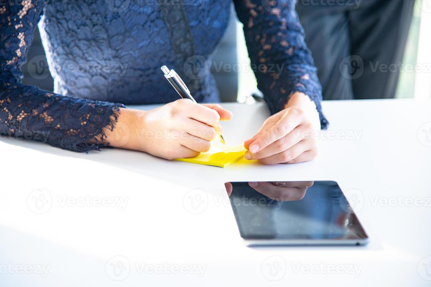 junge geschäftsfrau arbeitet, schreibt auf papier oder notizblock und trifft sich mit dem mitarbeiter im büro über die zukunft des unternehmens foto