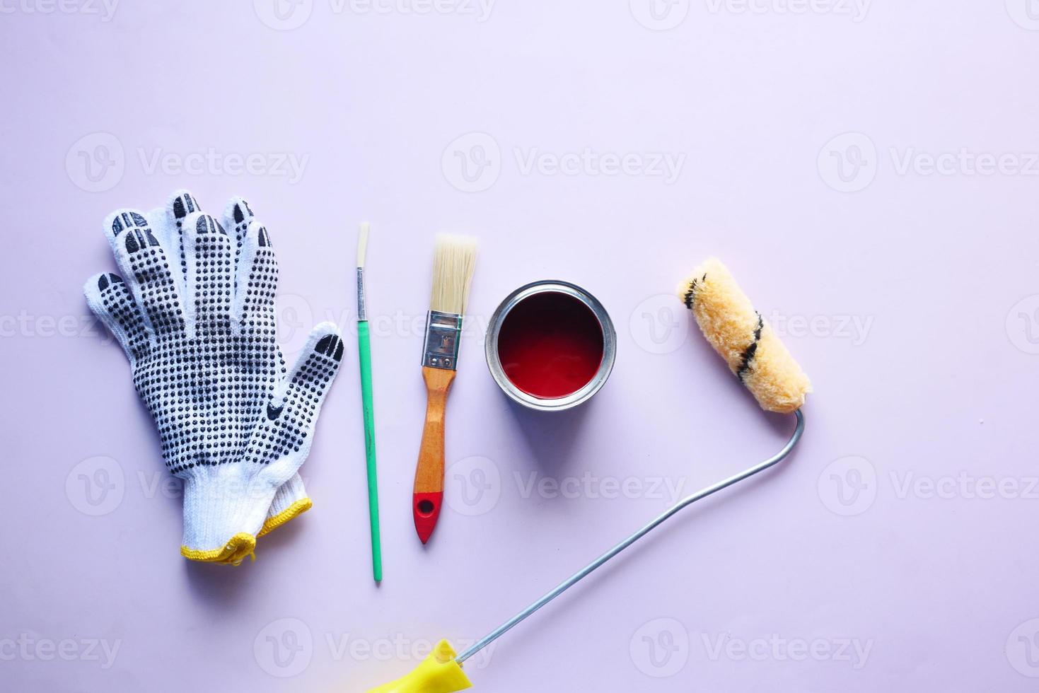 Draufsicht auf einen Pinsel, Handschuhe und Farbe auf dem Tisch foto