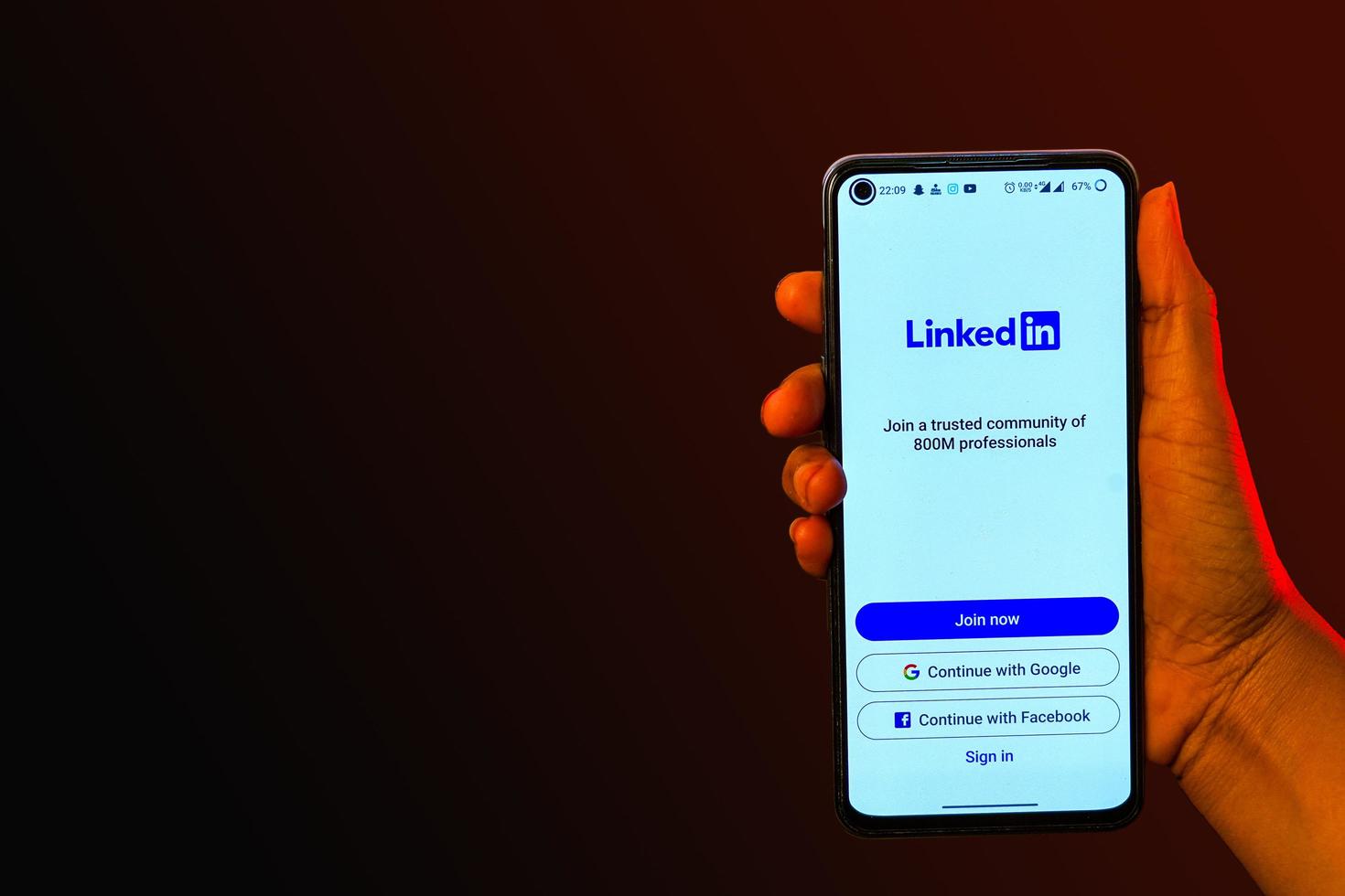 indisches mädchen, das smartphone in der hand hält und linkedin-banner zeigt foto