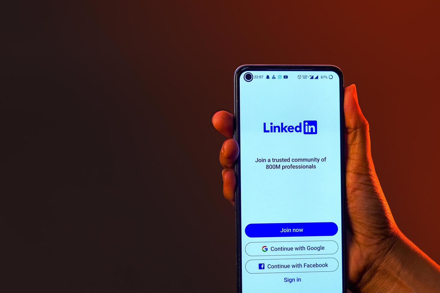 indisches mädchen, das smartphone in der hand hält und linkedin-banner zeigt foto