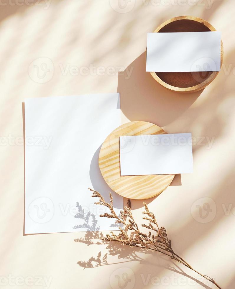 Flache Lage der Branding Identity Business Name Card auf gelbem Hintergrund mit Blume und Holzbehälter, Licht- und Schattenform, minimales Konzept für Design foto