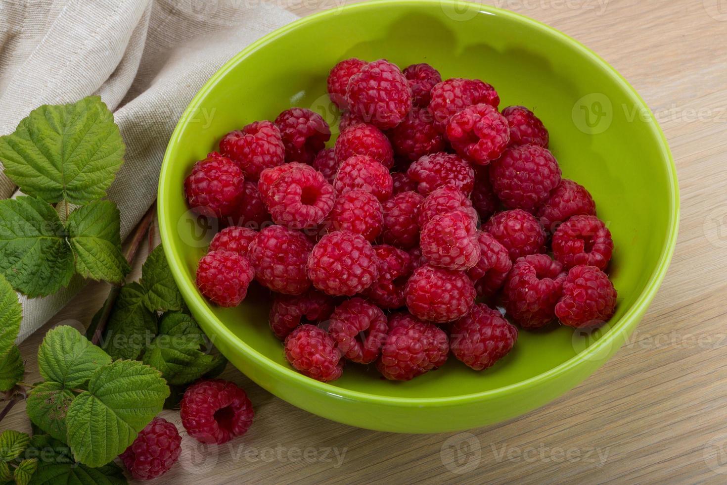 frische Himbeere in einer Schüssel auf hölzernem Hintergrund foto