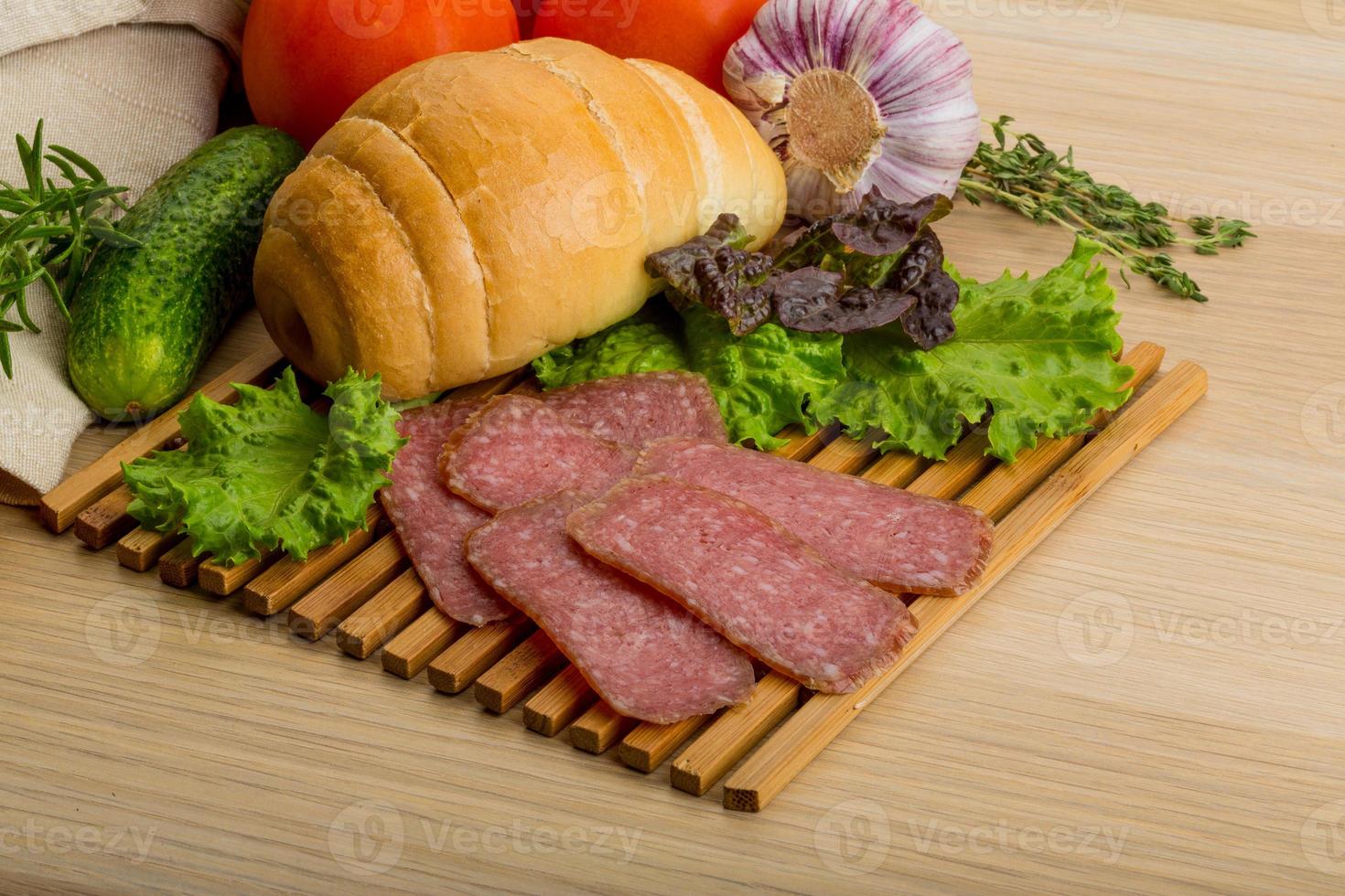 Salami auf Holzbrett und Holzhintergrund foto