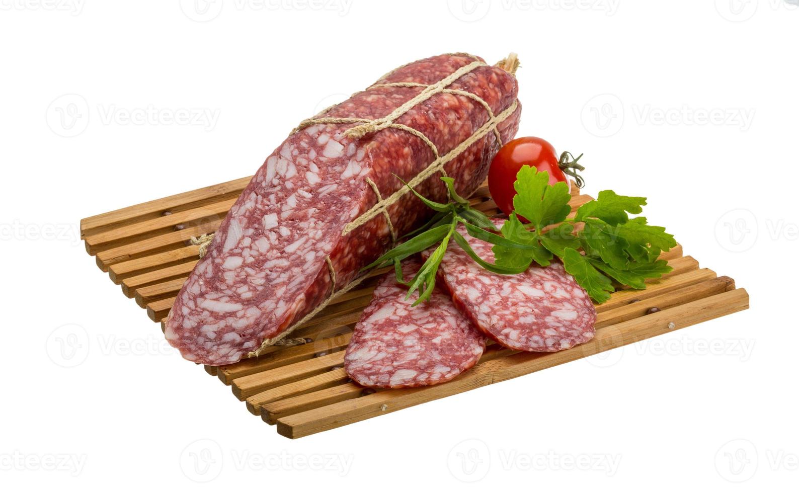 Salami auf Holzbrett und weißem Hintergrund foto