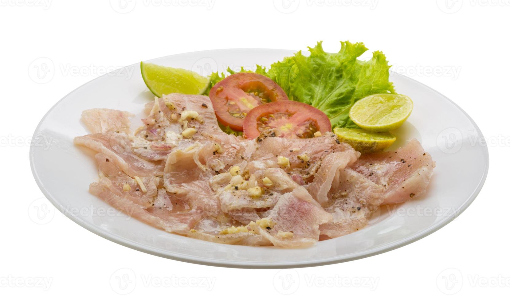 Schwertfisch-Carpaccio auf dem Teller und weißem Hintergrund foto