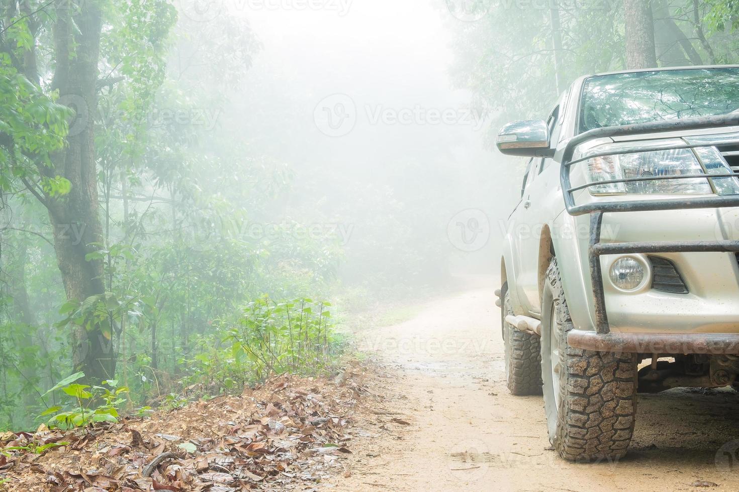 Rad-LKW-Nahaufnahme in Landschaftslandschaft mit schlammiger Straße. Extrem abenteuerliche 4x4-Fahrzeuge für den Transport oder Reisen oder Offroad-Rennen in der Natur im Freien. 4wd-Reifenauto auf Schmutzberg. foto