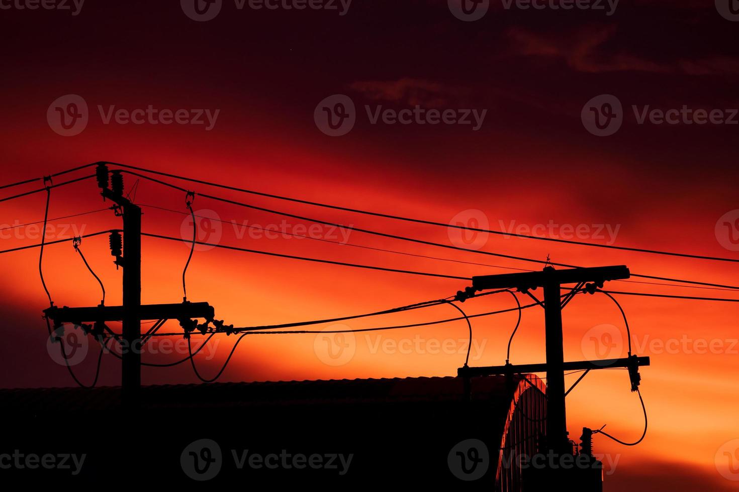 Silhouette von Hochspannungsmast und orangefarbenem blauem Himmelshintergrund am Everning-Tag foto