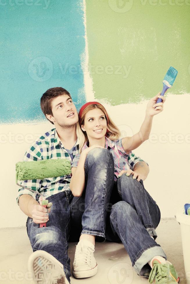 Glückliches Paar malt Wand im neuen Zuhause foto