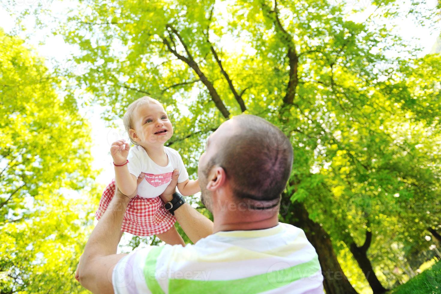 Mann und Baby spielen im Park foto