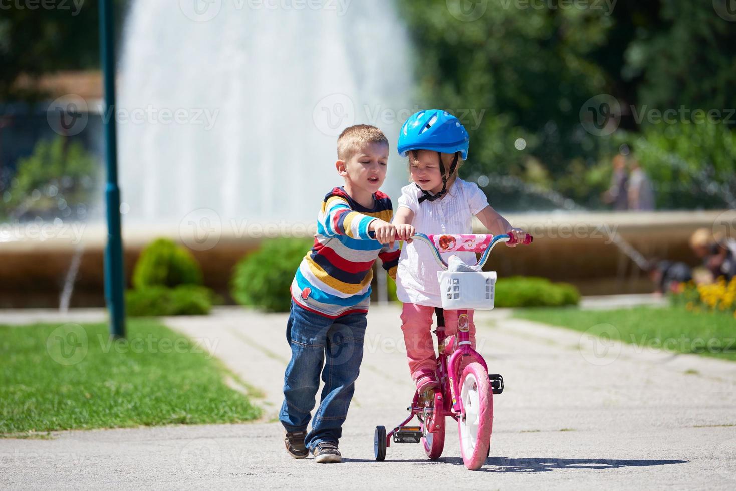 junge und mädchen im park lernen fahrrad zu fahren foto