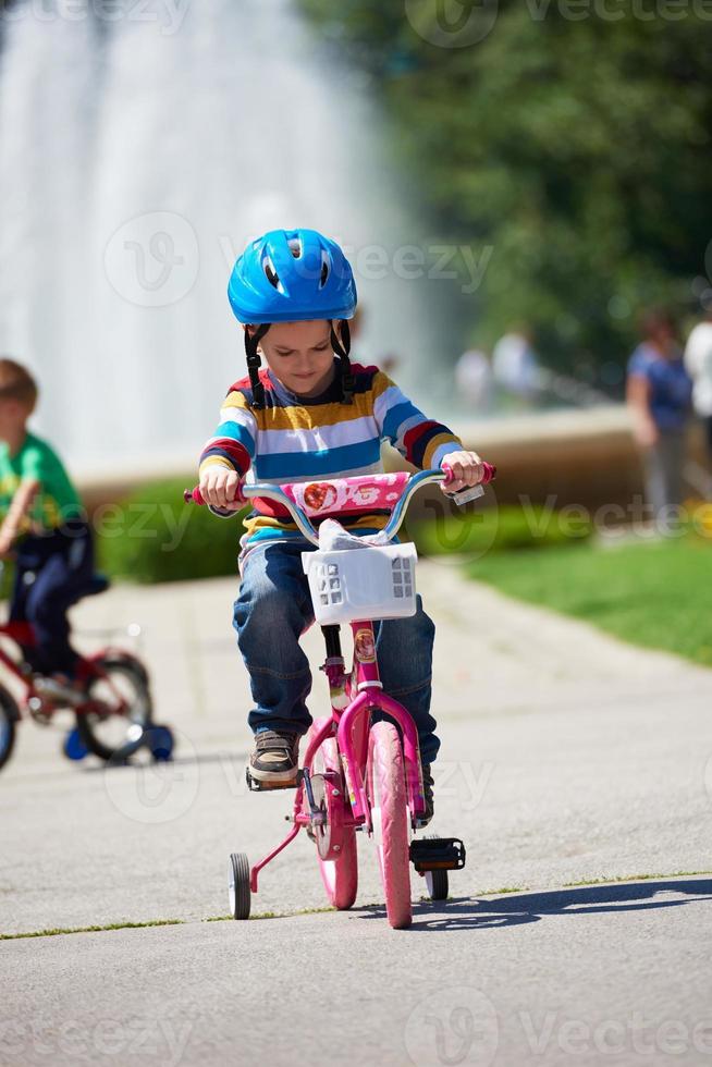 glücklicher junge, der lernt, sein erstes fahrrad zu fahren foto