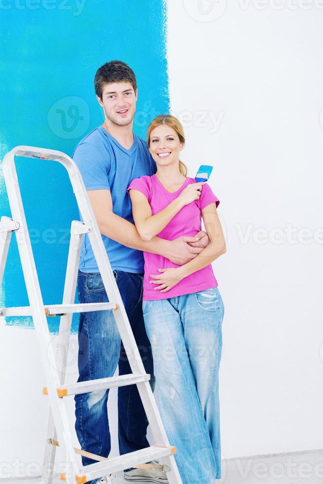 Glückliches Paar malt Wand im neuen Zuhause foto