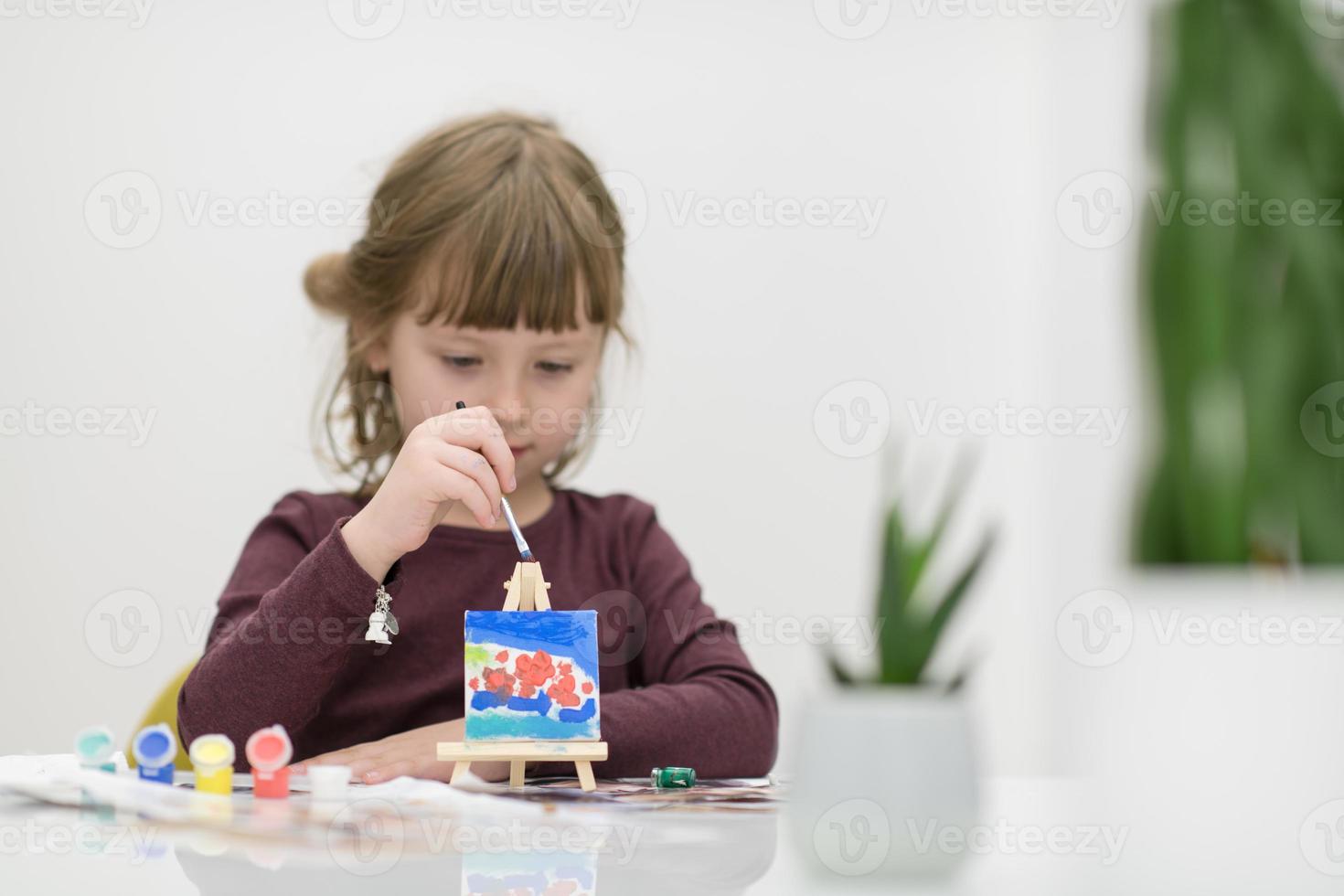 kleines Mädchen malt auf Leinwand foto