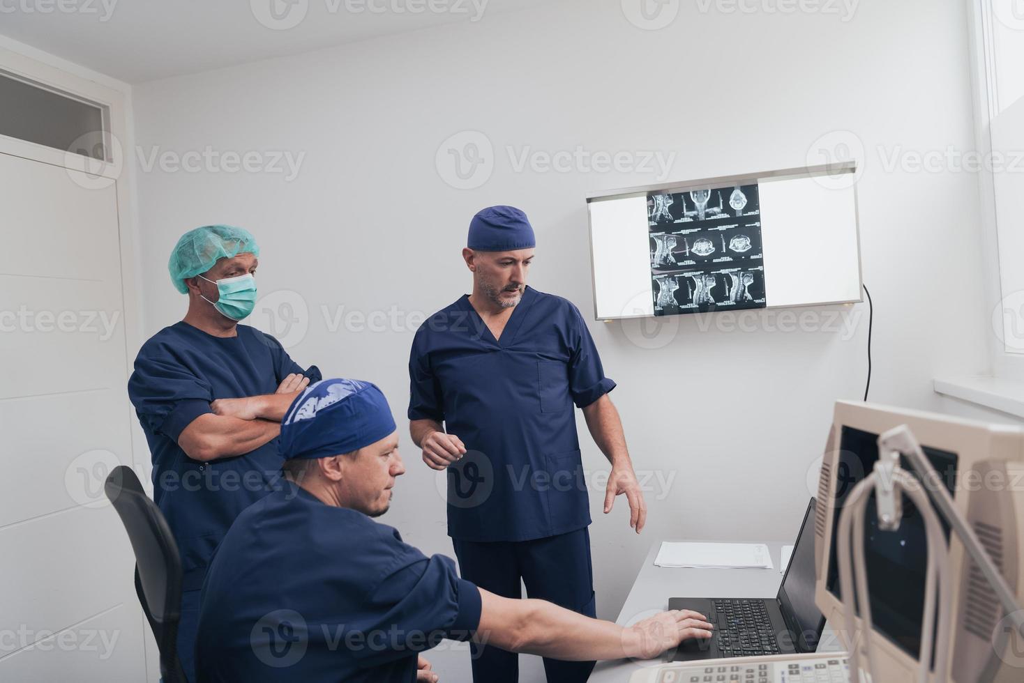 orthopädisches arztteam untersucht digitales röntgenbild in klinik oder krankenhaus foto