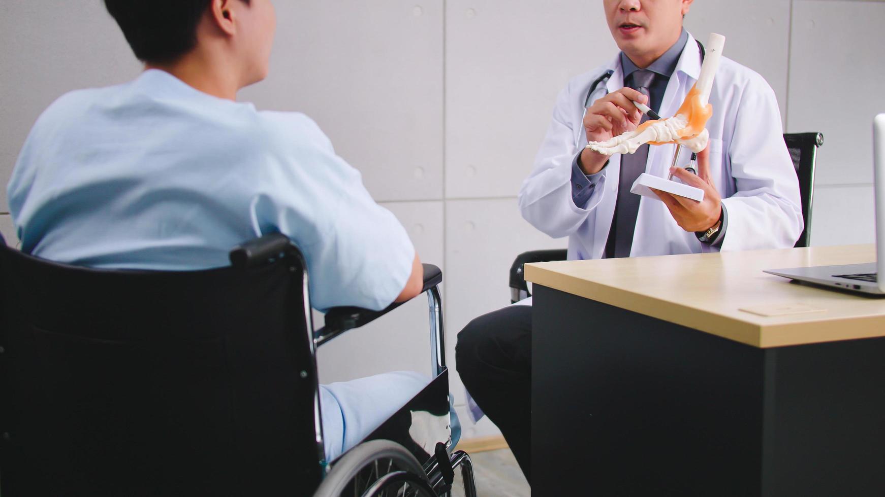 Ein männlicher Arzt erklärt dem Patienten die Ursache des Zustands des Patienten. foto