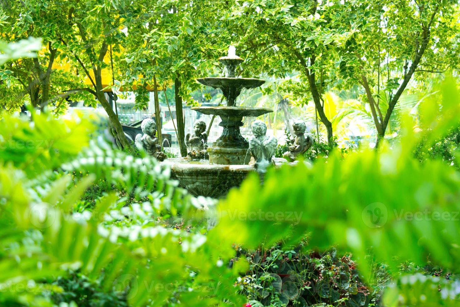 Springbrunnen im mehrstufigen Vintage-Stil im grünen Garten. foto