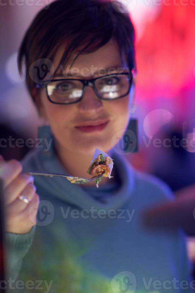 Frau isst leckeres Abendessen im modernen Restaurant foto