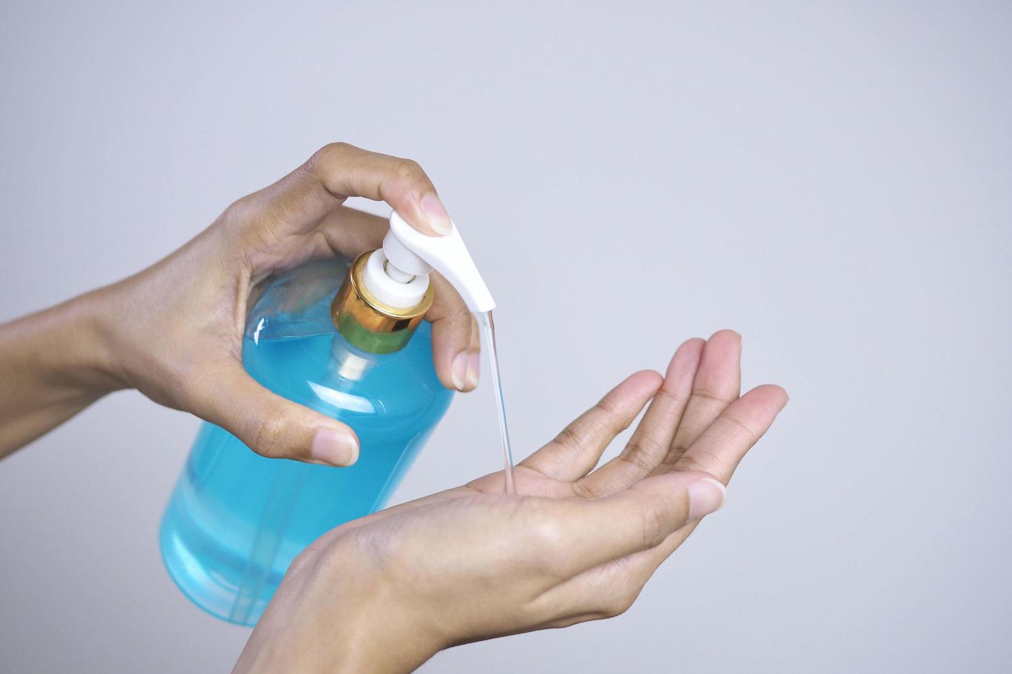frauen waschen sich die hände, um bakterien und viren mit einer flasche händedesinfektionsmittel für die händehygiene, gesundheitskonzept zu verhindern. foto