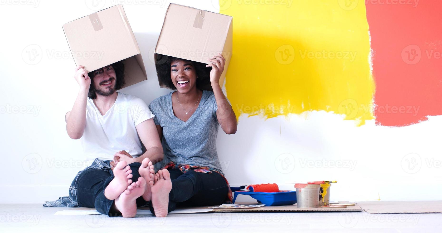 Junges multiethnisches Paar, das mit Kartons spielt foto