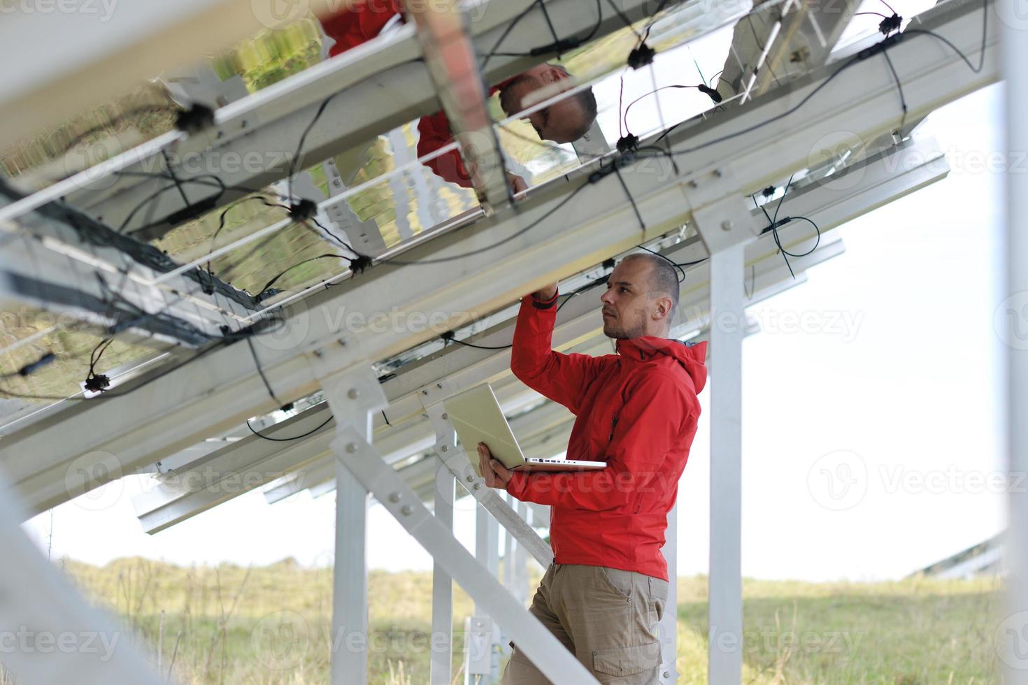 Ingenieur mit Laptop auf dem Feld der Solaranlage foto