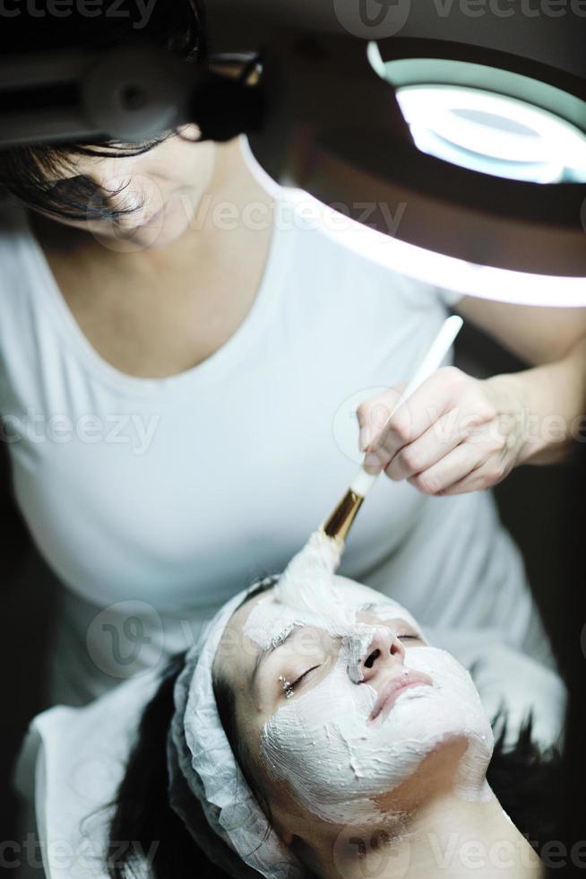 Frau mit Gesichtsmaske im Kosmetikstudio foto