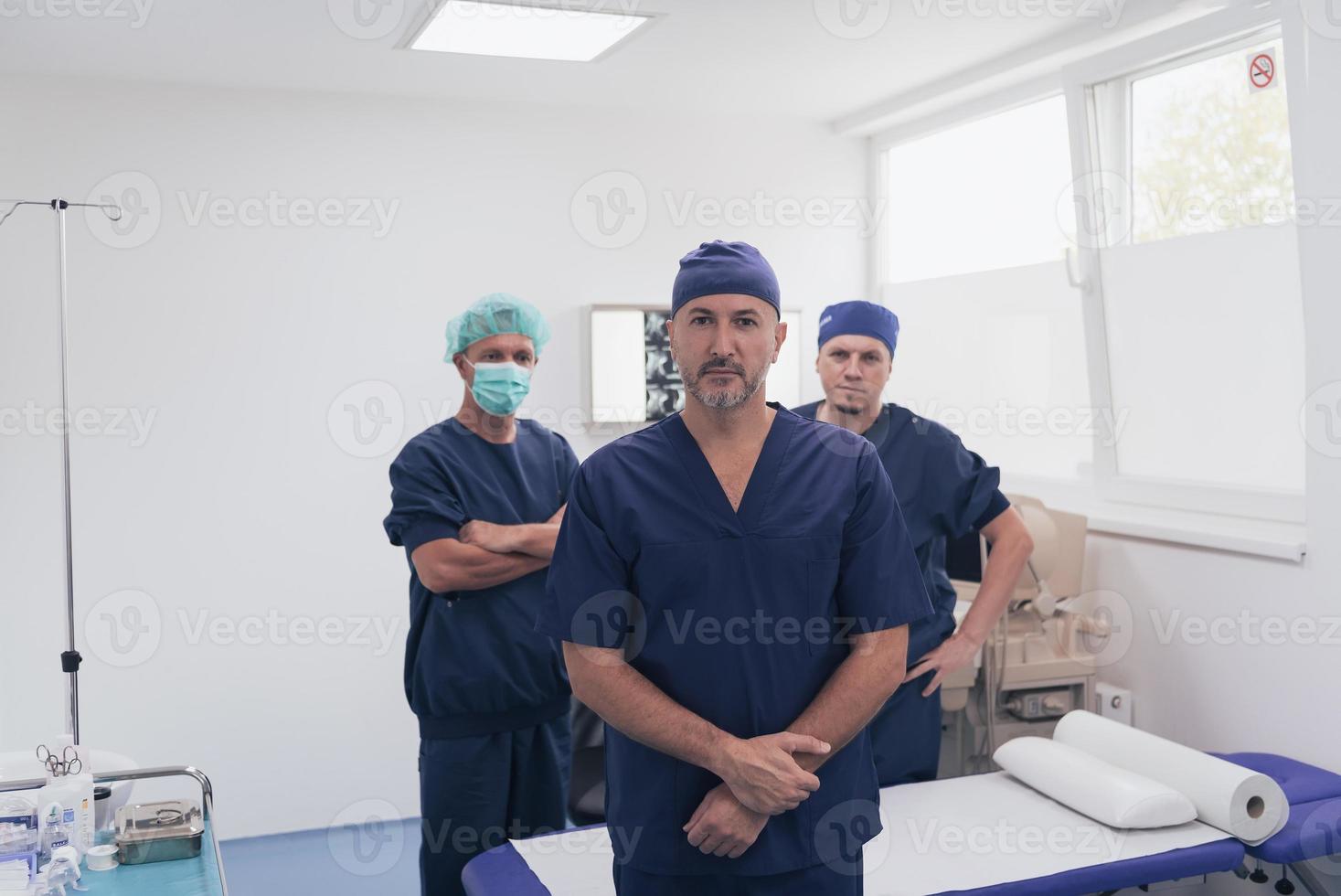 multiethnischer Orthopäde vor seinem medizinischen Team, der mit Gesichtsmaske in die Kamera schaut foto