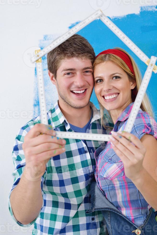 Glückliches Paar malt Wand im neuen Zuhause foto