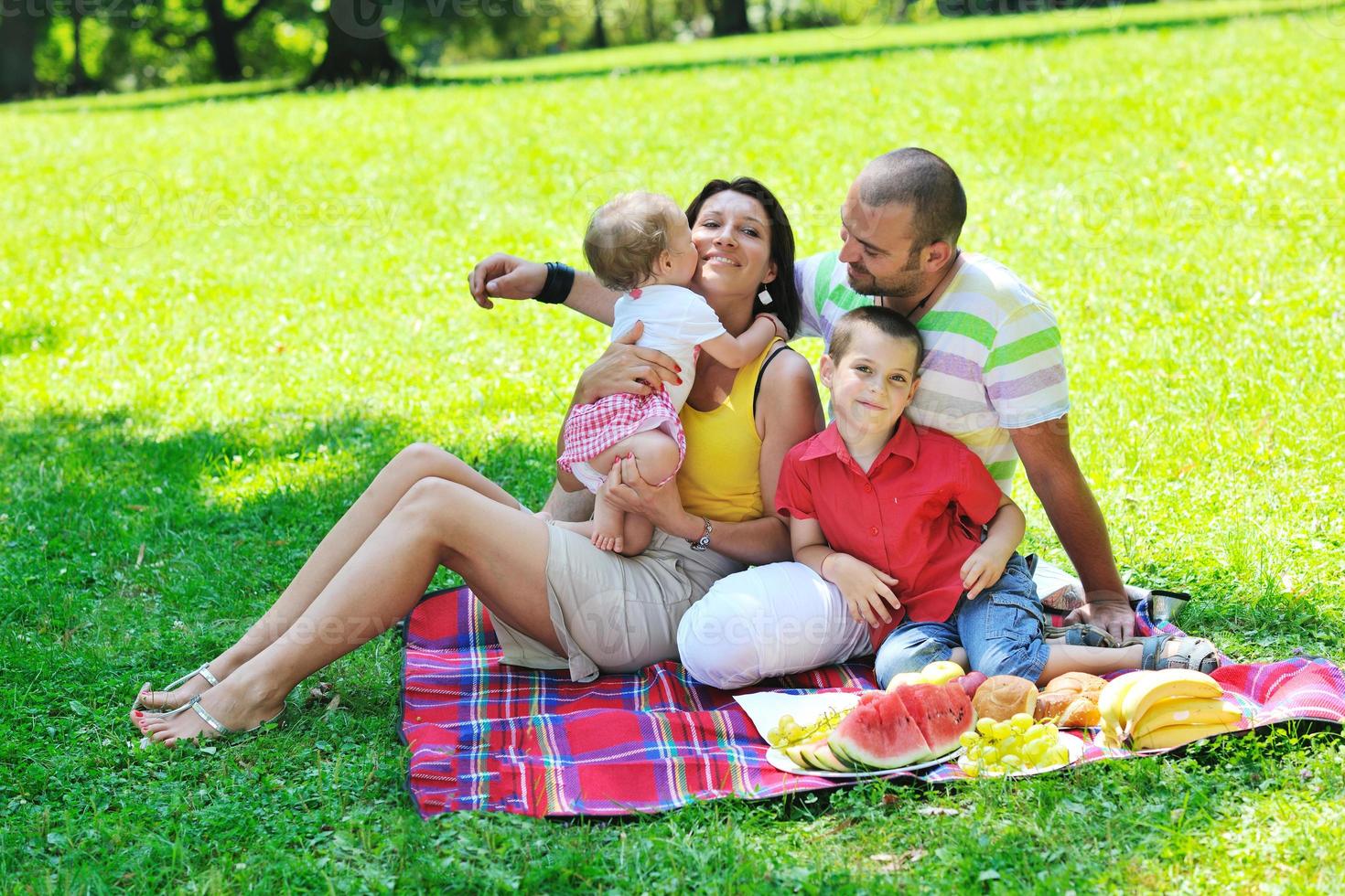 glückliches junges Paar mit ihren Kindern haben Spaß im Park foto