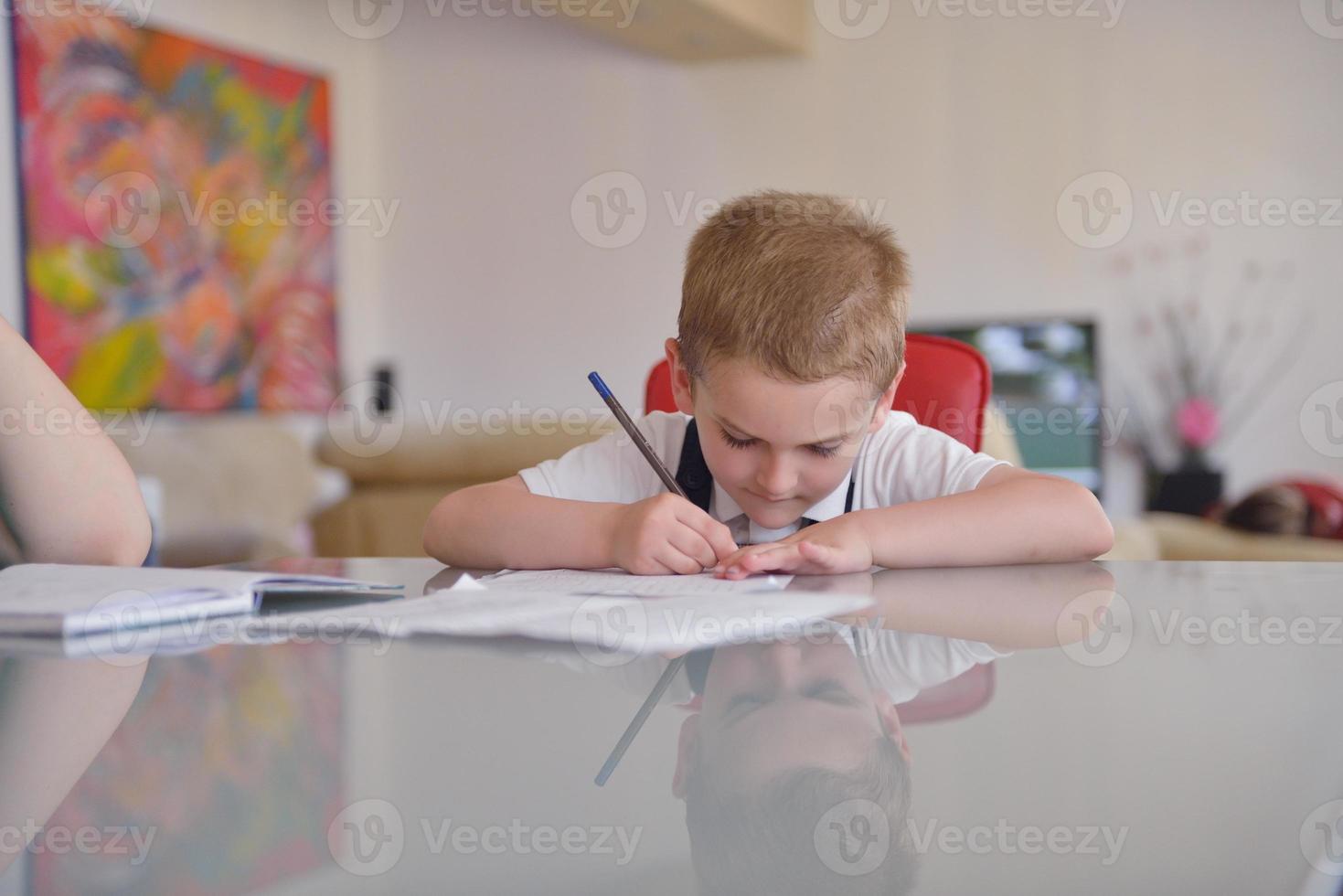 Junge macht Hausaufgaben foto