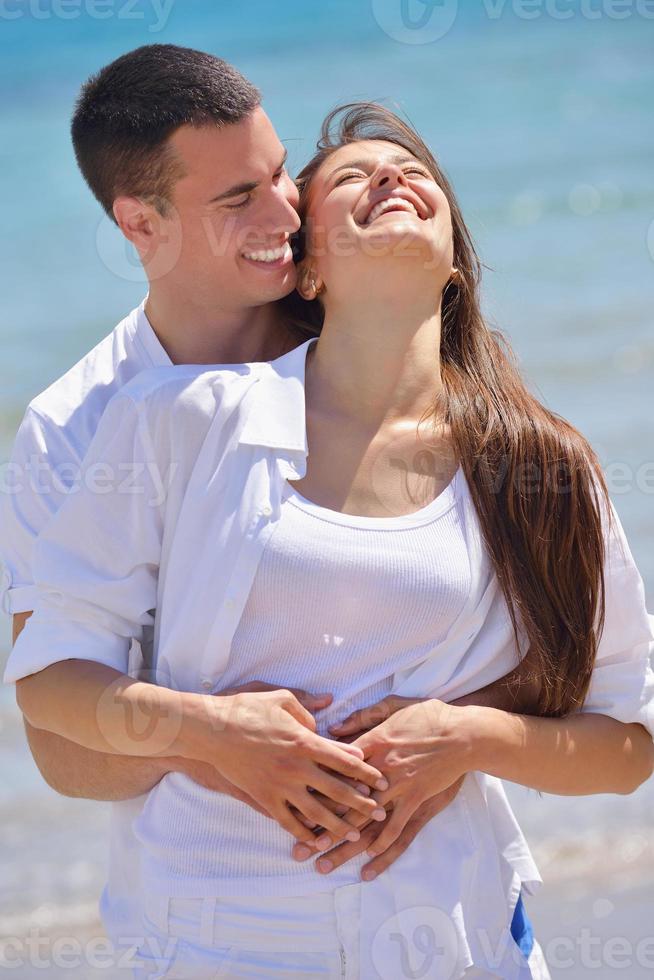 Glückliches Paar hat Spaß am Strand foto