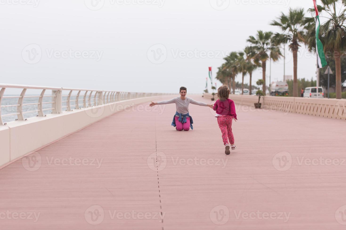 Mutter und süßes kleines Mädchen auf der Promenade am Meer foto