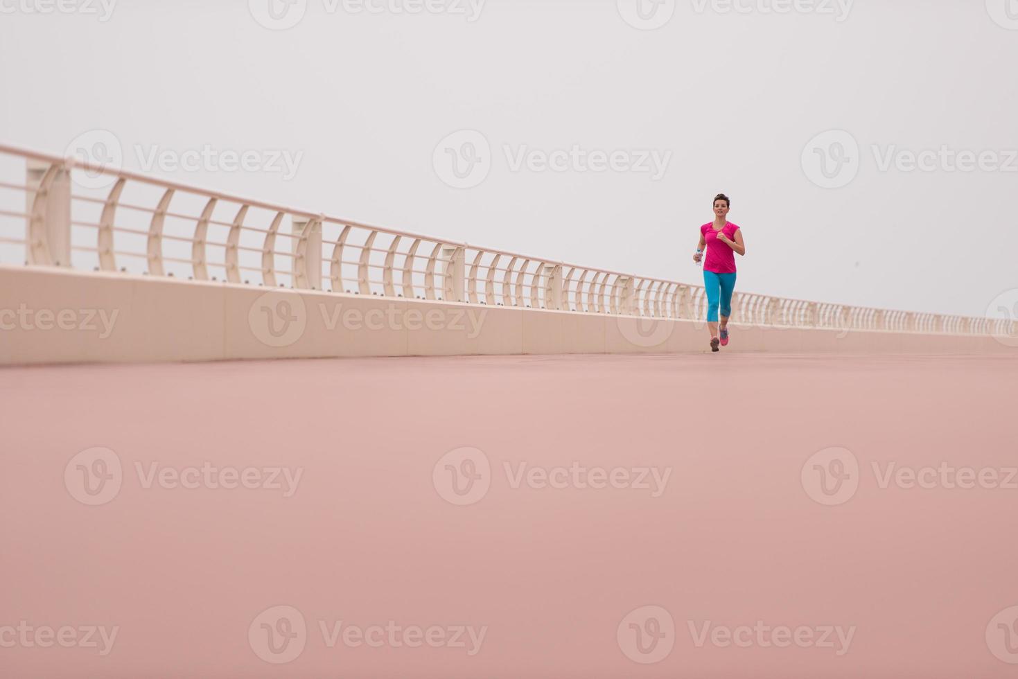 Frau, die damit beschäftigt ist, auf der Promenade zu laufen foto