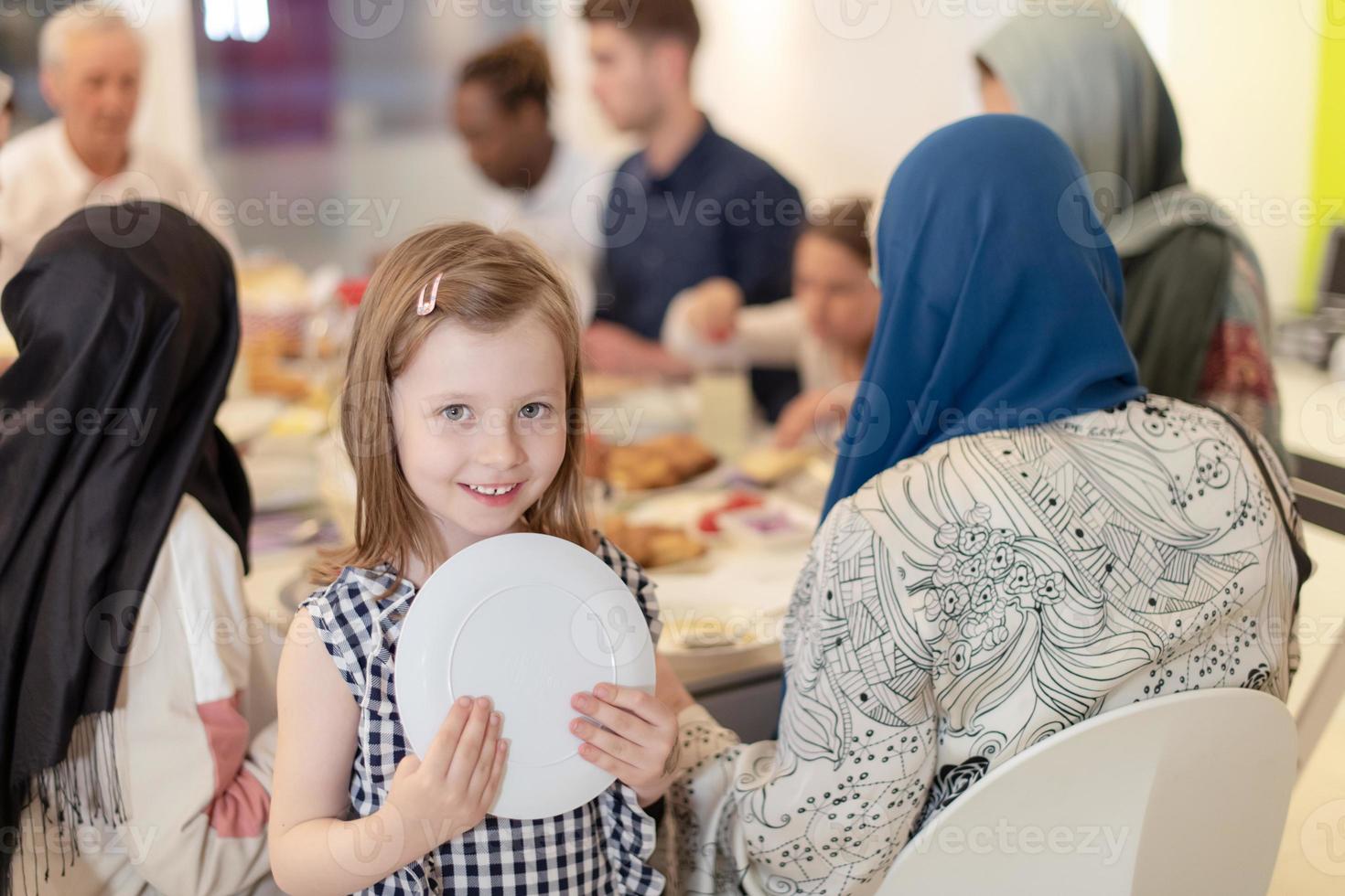 süßes kleines mädchen, das iftar-abendessen mit der familie genießt foto