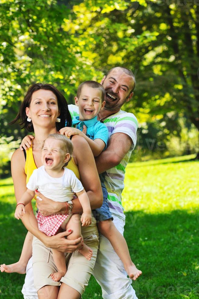 glückliches junges Paar mit ihren Kindern haben Spaß im Park foto